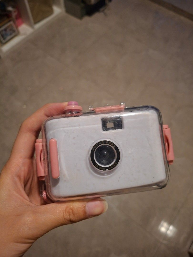 White Digital Camera with Waterproof Casing (Category: Cameras) located in Cavite. Submitted by loved.ky (Listing ID 1446051262, Image 1). Description: - White digital camera - Includes clear waterproof casing with pink accents - Casing has secure clips - Compact camera with lens and viewfinder - Battery compartment accessible after removing casing - Ideal for travel and outdoor adventures.