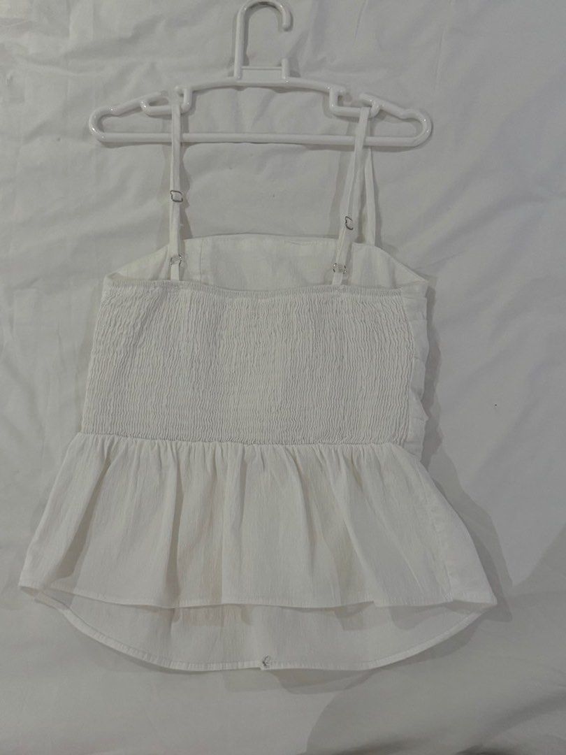 White Smocked Peplum Top (Category: Sleeveless) located in Makati City. Submitted by oursummerstitches (Listing ID 1446111074, Image 3). Description: - White peplum top - Smocked back for a comfortable fit - Adjustable straps for a customized look - Ruched detail at the waist to flatter your figure - Pleated peplum hem for a stylish flair - Estimated size: xs to s - Versatile for casual outings or dressing up - bought in Korea .
