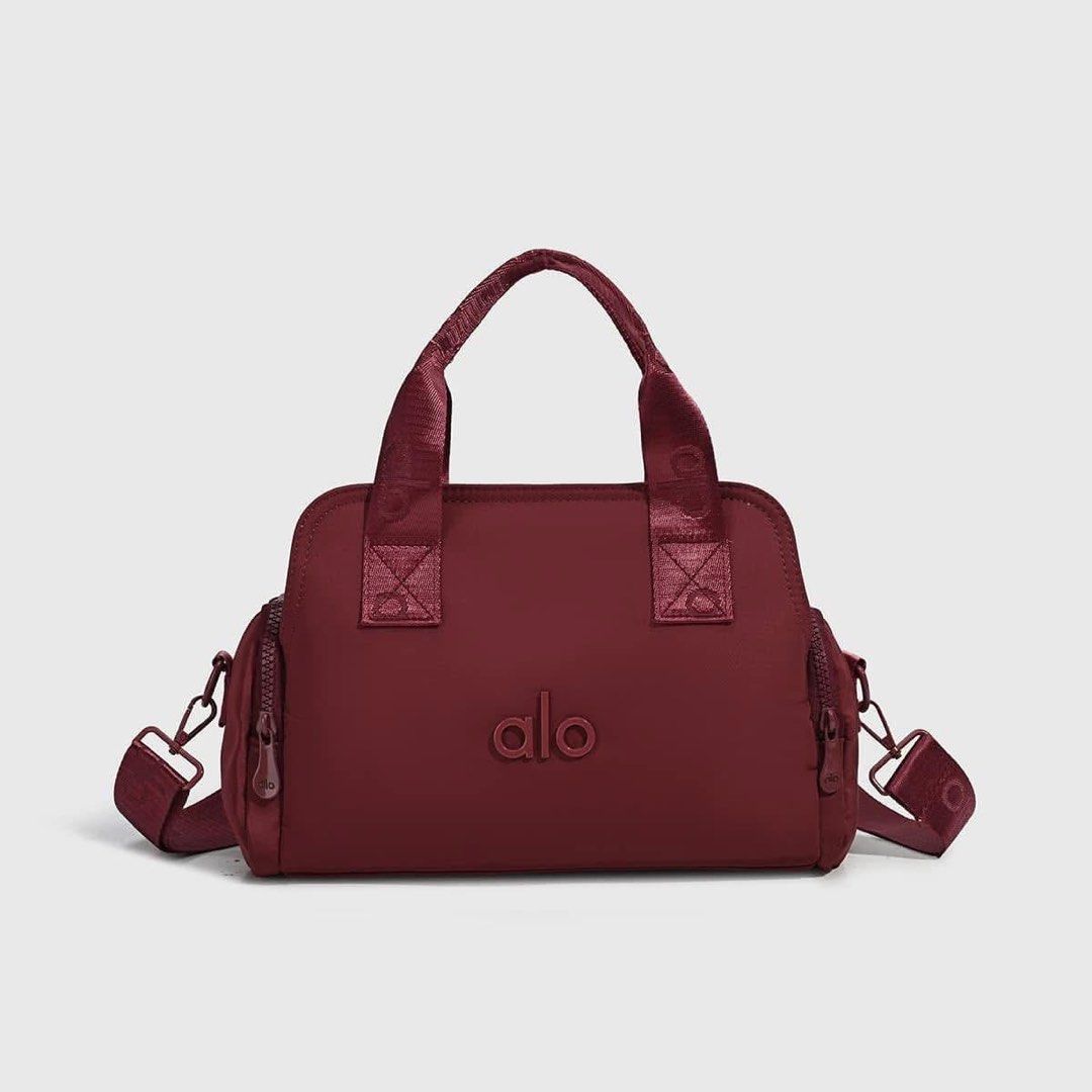 ALO Yoga Duffel Bag - Multiple Colors Available (Category: Tote Bags) located in Manila. Submitted by ziannne (Listing ID 1446196020, Image 2). Description: Cute and functional duffel bag. Perfect size for gym or weekend trips. Has top handles and a detachable shoulder strap. Features side zip pockets for easy access. The ALO logo is embossed on the front. Available in several colors..