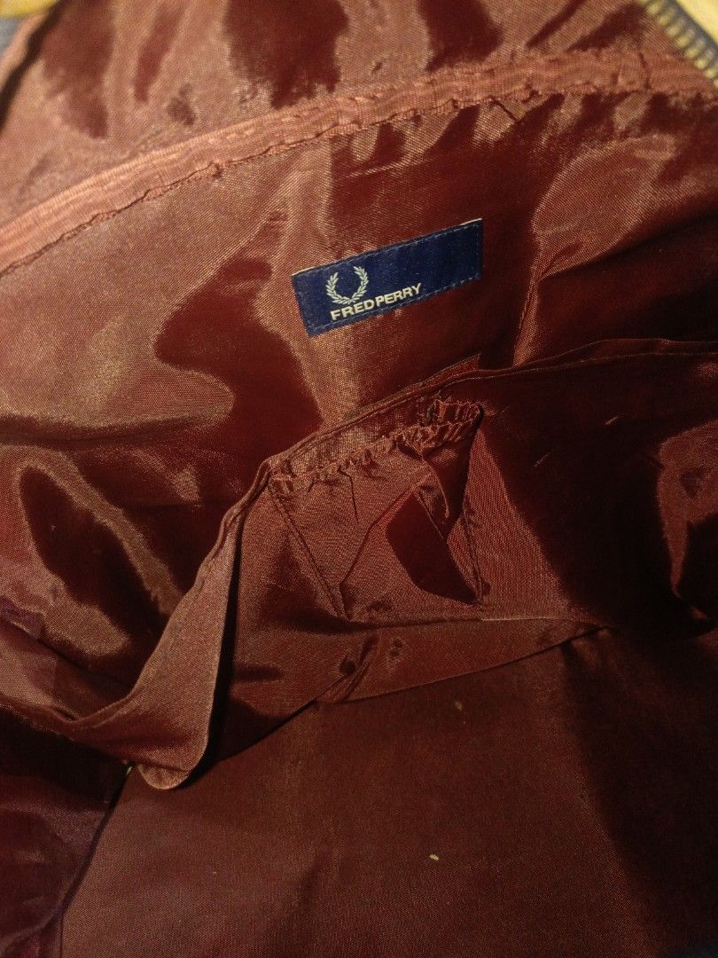 Authentic Vintage Fred Perry Barrel Bag (No Sling) (Category: Briefcases) located in Aparri. Submitted by jackdeclutter1111 (Listing ID 1446269248, Image 3). Description: Authentic Vintage Fred Perry Grip / Barrel Bag Color: Maroon / Navy Blue details Condition: Heavily used. Has visible surface scuffs/scratches due to age. No rips or deep tears. Issue: No more long shoulder sling strap included. Main hand straps are sturdy. Selling as-is. Perfec