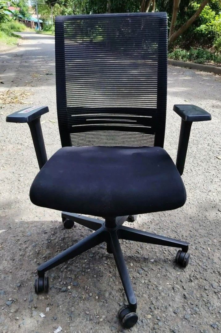 Black Ergonomic Mesh Office Chair with Armrests (Category: Office Furniture & Fixtures) located in Muntinlupa City. Submitted by freestone_d54257 (Listing ID 1446245685, Image 2). Description: - Black ergonomic office chair - Breathable mesh back for comfort - Padded seat for extended sitting - Adjustable armrests for personalized support - Five-star base with wheels for easy mobility - Ideal for home office setups - Good overall condition.
