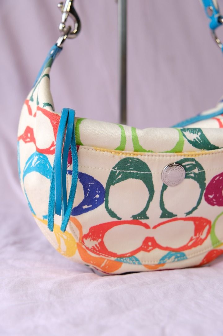 Coach Multicolor Scribble Hampton Hobo Bag (Category: Luxury Bags & Wallets) located in Cabuyao City. Submitted by velvetbelleph (Listing ID 1446258623, Image 2). Description: Add a fun pop of color to your collection with this Coach Multicolor Scribble Hampton Hobo Bag. It features a colorful Coach-inspired scribble print on a light-colored body, complemented by blue leather trim and handle, silver-tone hardware, and a convenient front pocket. I