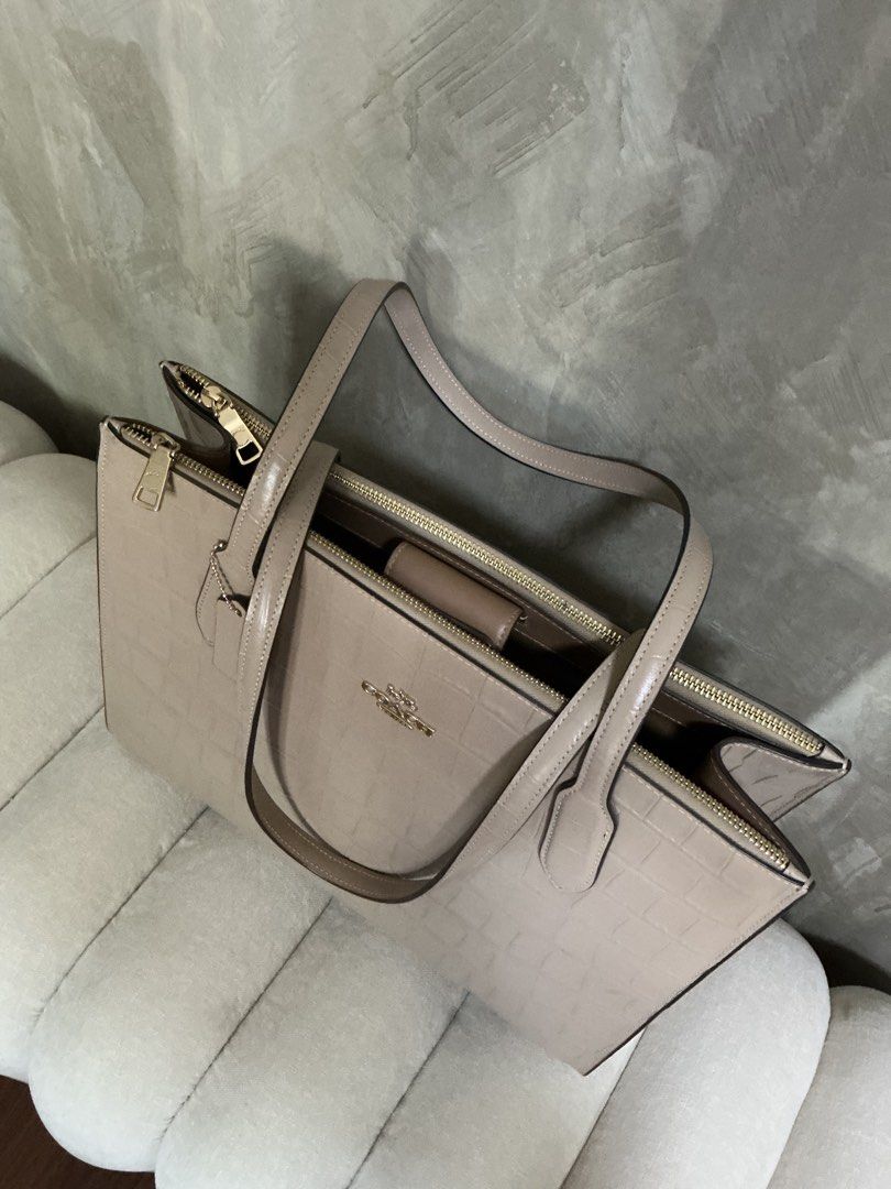 Coach Nina Tote Bag (Category: Luxury Bags & Wallets) located in Bulacan. Submitted by slvvvxx (Listing ID 1446251669, Image 3). Description: Coach Nina Tote Bag – Sleek, Structured, and Perfect for Daily Use Material: Crocodile-embossed leather Color: Taupe Design Details: Classic Coach metallic logo hardware, sturdy dual shoulder straps, and a detachable leather hangtag. Interior: Fabric-lined with multi-function pockets for easy organization. 