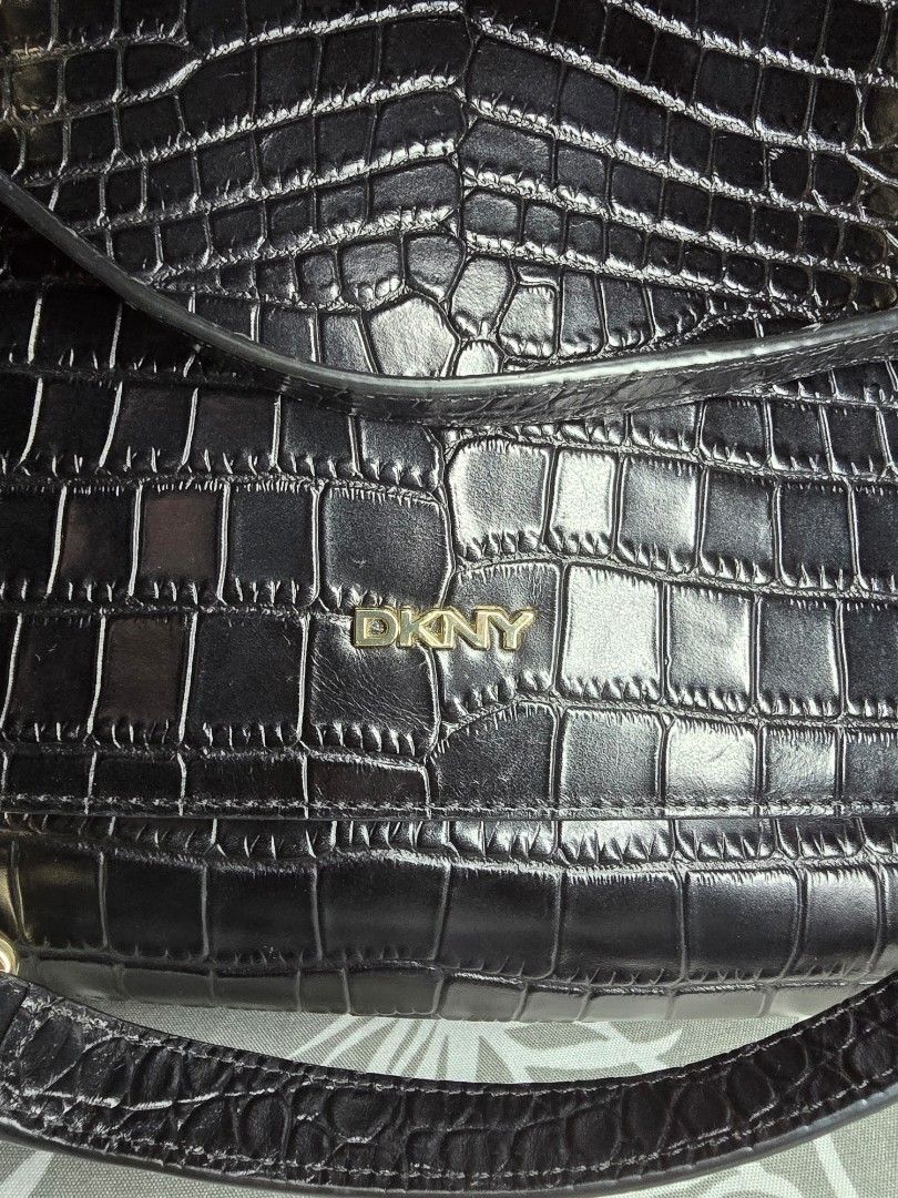 DKNY Black Croc Embossed Chain Shoulder Bag (Convertible) (Category: Luxury Bags & Wallets) located in Taguig. Submitted by ara_shoppe_mnl (Listing ID 1446199423, Image 3). Description: - Black DKNY shoulder bag - Croc embossed texture - Gold chain strap (convertible) - DKNY logo lining - Interior zippered pocket and open pocket - Clean inside - Versatile for nights out or everyday use - With minimal signs of use (please refer to the last 2 photo