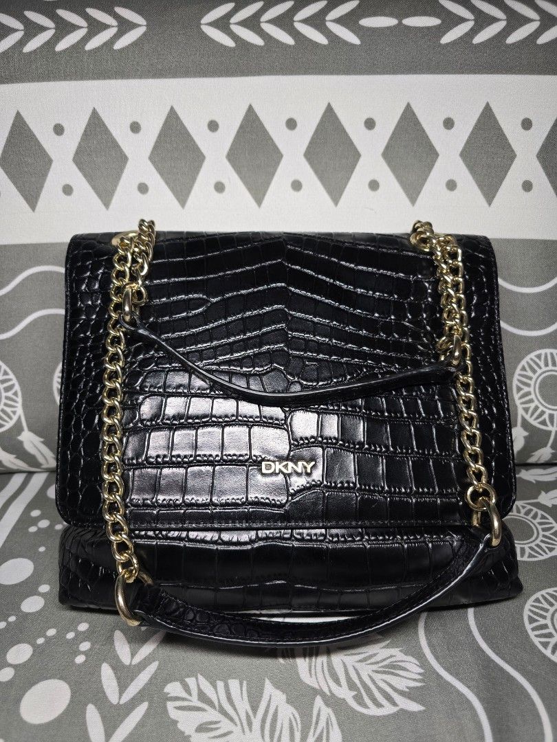 DKNY Black Croc Embossed Chain Shoulder Bag (Convertible) (Category: Luxury Bags & Wallets) located in Taguig. Submitted by ara_shoppe_mnl (Listing ID 1446199423, Image 1). Description: - Black DKNY shoulder bag - Croc embossed texture - Gold chain strap (convertible) - DKNY logo lining - Interior zippered pocket and open pocket - Clean inside - Versatile for nights out or everyday use - With minimal signs of use (please refer to the last 2 photo