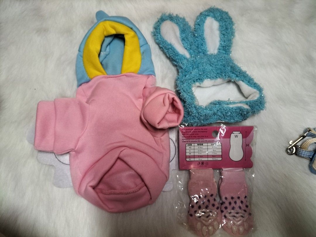 Dog Clothes, Bunny Hat, and Pet Socks Bundle (Category: Homes & Other Pet Accessories) located in Taytay. Submitted by tina.bel.s (Listing ID 1446188651, Image 1). Description: Pet Items for Sale Pink hoodie Bundle - 300php -Includes Pink hoodie(XS size), Rabbit head wear and 2 pc socks Chucky Costume for dogs- 180 php - Costume and wig Cute Pet Leash( brand new) - 90php each Pet leash adjustable color Red- 150 php Pet Carrier Cream and orange ch