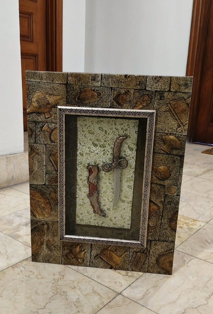 Framed Dagger and Sheath Display (Category: Wall Decor) located in Taguig. Submitted by thrifthub.ph (Listing ID 1446282641, Image 1). Description: Unique wall decor piece. Features a decorative dagger and sheath encased in a textured frame. The frame has a stone-like appearance with embossed details. Great for adding a statement to any room..