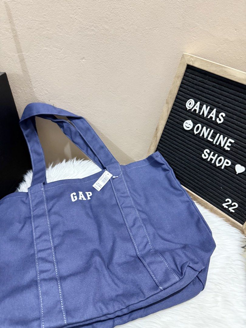 Gap blue canvas tote bag featuring an embroidered logo. (Category: Tote Bags) located in Las Pinas. Submitted by anasonlineshophtplaspinas (Listing ID 1446227429, Image 1). Description: This is a Gap blue canvas tote bag featuring an embroidered logo.Material: It is made from 100% cotton.Price: The tag indicates a price of $39.99.Usage: It is designed for daily utility and is described as spacious..