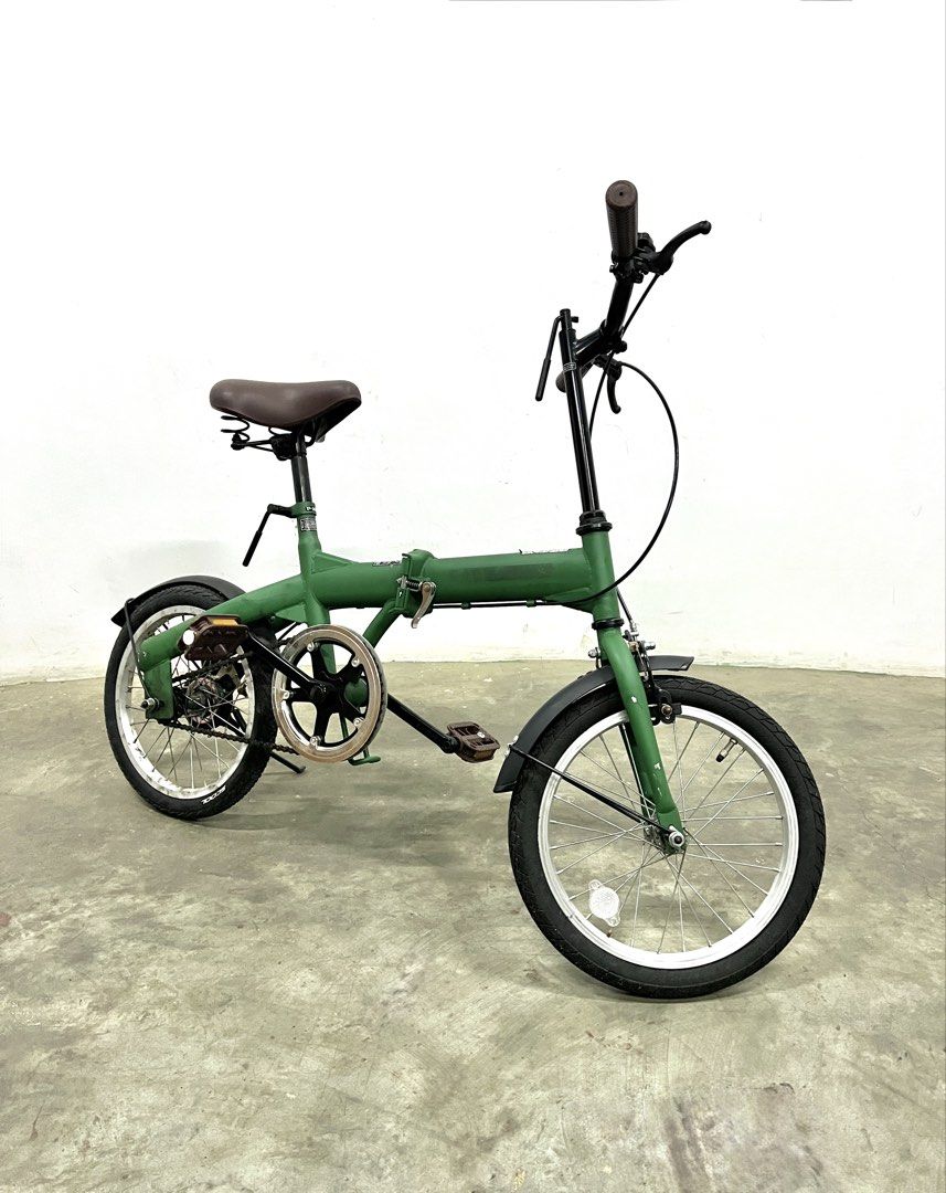 Green Folding Bicycle with Brown Saddle and Handle Grips (Category: Bicycles) located in Santa Rosa. Submitted by annie_annie83 (Listing ID 1446215488, Image 1). Description: - Green folding bike - Comfortable brown saddle and matching grips - Fenders on both wheels for protection - Easy to fold and store, ideal for small spaces - Great for daily commutes or leisurely rides - Well-maintained and ready for a new owner.