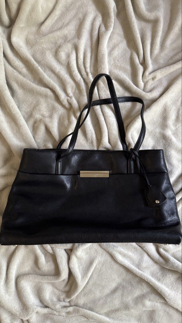 Kate Spade Maiden Way Saffiano Clark Tote Bag (Category: Luxury Bags & Wallets) located in Quezon City. Submitted by raqsinabox (Listing ID 1446199404, Image 1). Description: - Classic black leather tote by Kate Spade - Spacious interior to fit all your essentials - 3 compartments (middle one is zippered) - Sleek metal accent on the front for a touch of elegance - Comes with its original dust bag - Ideal for both work and everyday use - Generous 