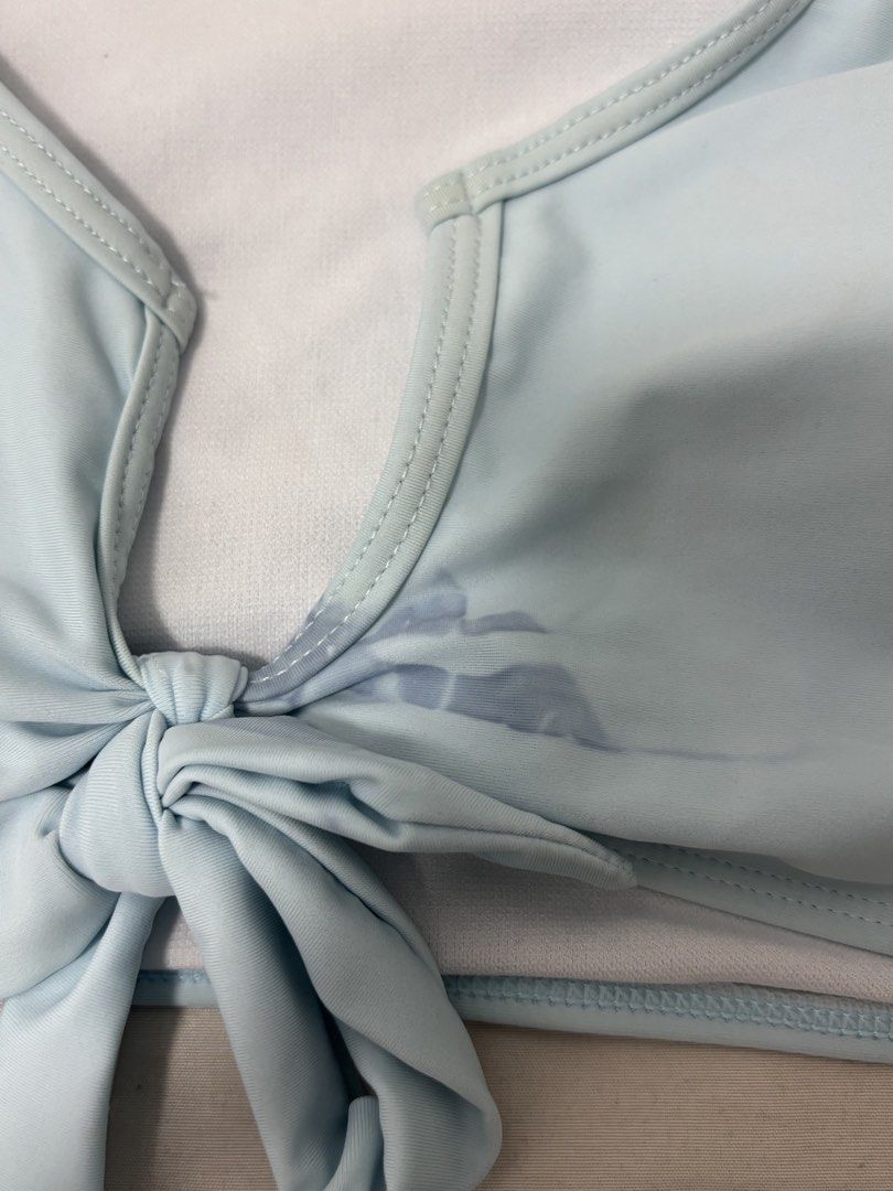 Light Blue Tie-Front Bikini Set with Ruched Shorts (Category: Bikinis & Swimsuits) located in Quezon City. Submitted by notgigim___ (Listing ID 1446317980, Image 2). Description: - Cute light blue bikini set - Top: Short sleeves, tie front - Bottoms: High-waisted, ruched sides, adjustable ties - Ideal for beach or pool - there’s a stain behind the bow but not noticeable .