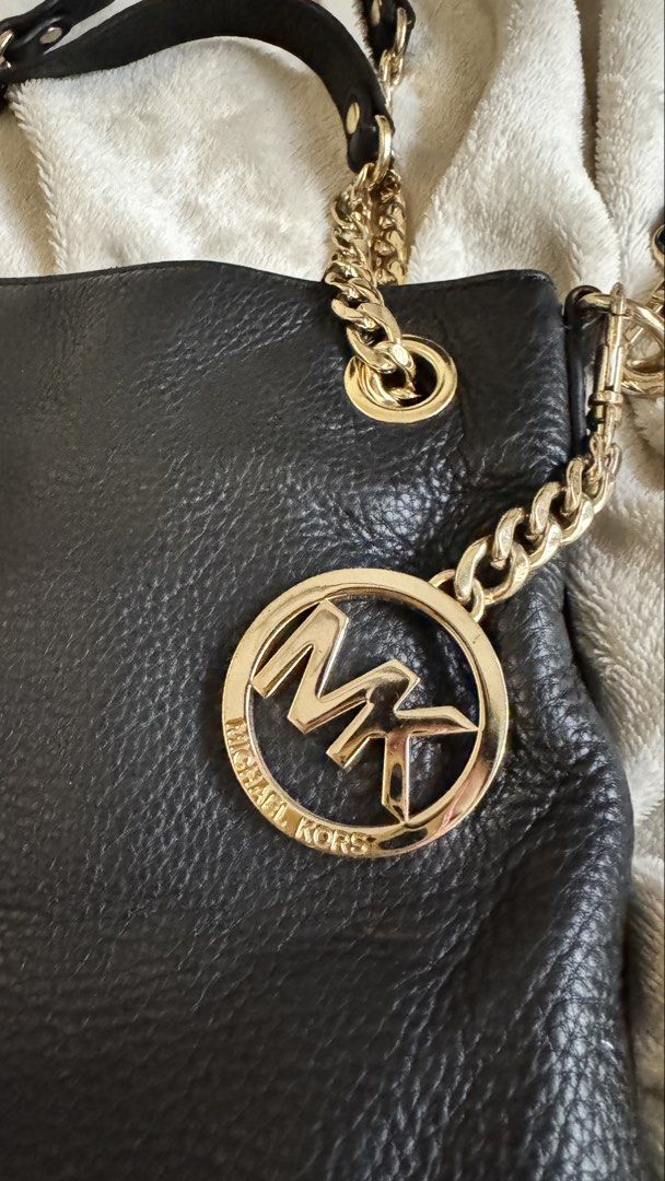Michael Kors Black Pebbled Leather Shoulder Bag (Category: Luxury Bags & Wallets) located in Quezon City. Submitted by raqsinabox (Listing ID 1446198536, Image 2). Description: - Authentic Michael Kors shoulder bag - Classic black leather - Elegant gold hardware chain detailing - Gold-tone chain handles and signature round MK medallion charm - Includes original dust bag - Dimensions: Approx. 12" wide x 10" tall - Ideal for everyday wear.