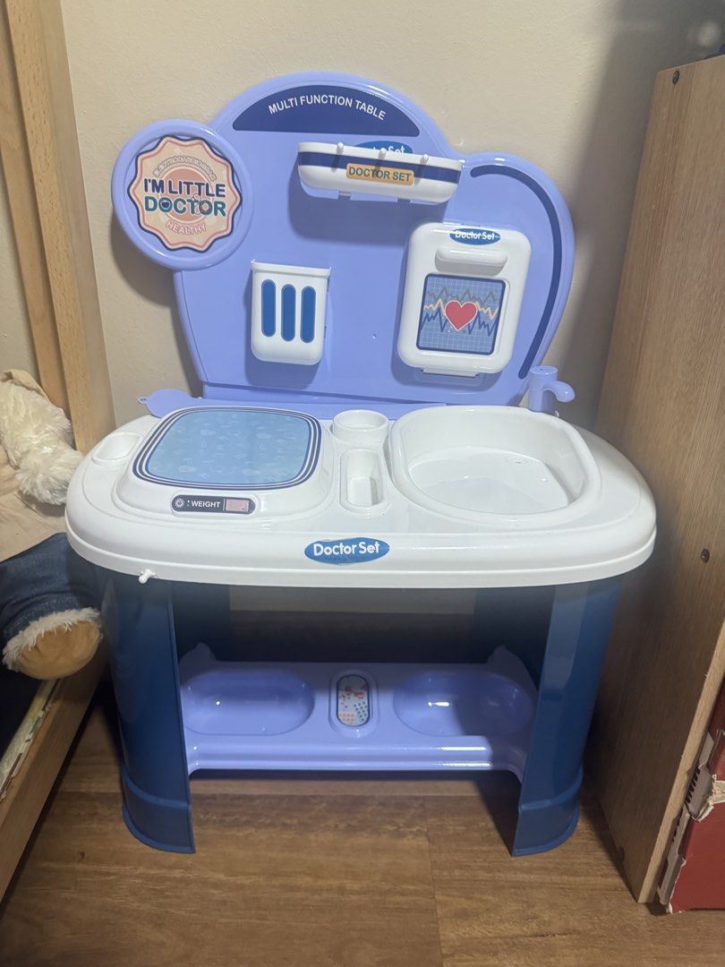 Multi Function Doctor Set Play Table (Category: Infant Playtime) located in Singapore. Submitted by flourishcookie (Listing ID 1446197816, Image 1). Description: - Fun multi-function doctor play table for kids - Features a sink, scale, and medical accessories holder - Pretend monitor with heart rate display - Encourages imaginative and pretend play - Lower shelf for extra storage - Perfect for aspiring little doctors.