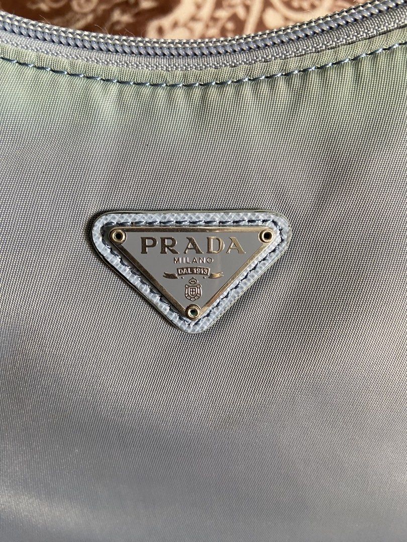 PRADA TESSUTO NYLON MINI Re-Edition 2000 (Category: Luxury Bags & Wallets) located in Pili. Submitted by rgthriftflip29 (Listing ID 1446177992, Image 2). Description: - Authentic / Not Guaranteed -Prada shoulder bag - Made in Italy - Light blue nylon material - Silver hardware - Zipper closure - COMPLETE Interior Prada Milano tag - Ideal for everyday use, fits essentials, and elegance L: 9” W: 3” D: 5” Handle: 7” ❌ISSUE: MISSING CLOCHETTE x MILD 