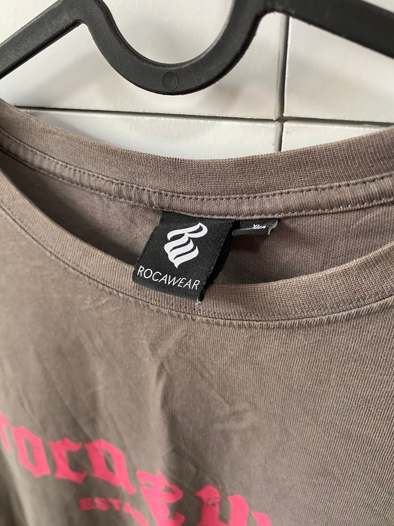 Rocawear Pink Checkerboard (Category: Tshirts & Polo Shirts ) located in Tagaytay City. Submitted by grayl_thrift (Listing ID 1446314583, Image 3). Description: - Brown Rocawear t-shirt - Features Rocawear logo and 'Established 1999' on the front - Checkerboard graphic with Rocawear logo on the back - Oversized fit - Ideal for streetwear style.