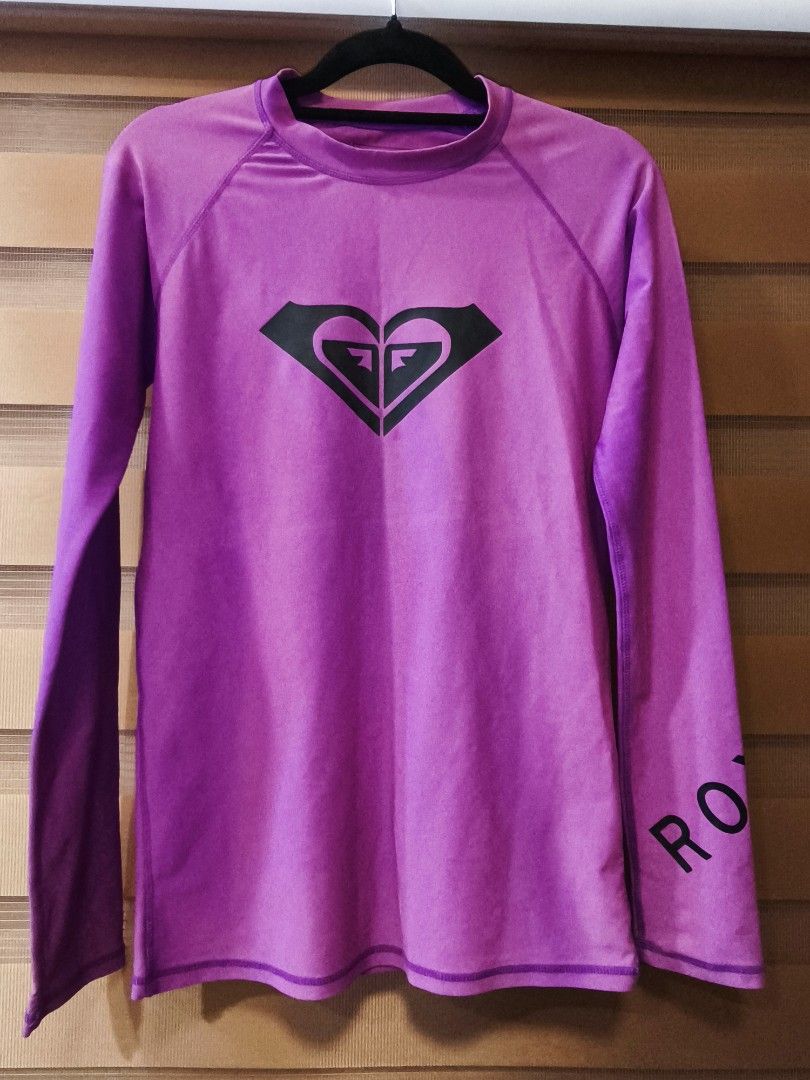 Roxy Purple Long Sleeve Rash Guard Top (Category: Rash guard) located in Baguio. Submitted by zia_zab (Listing ID 1446309041, Image 1). Description: - Purple Roxy long sleeve rash guard - Features Roxy logo on front and sleeve - Made from a comfortable nylon and spandex blend - Ideal for surfing, swimming, or any water activity - Provides a comfortable fit for active days - Refer to label for care instructions -In very good condition -No flaws -C