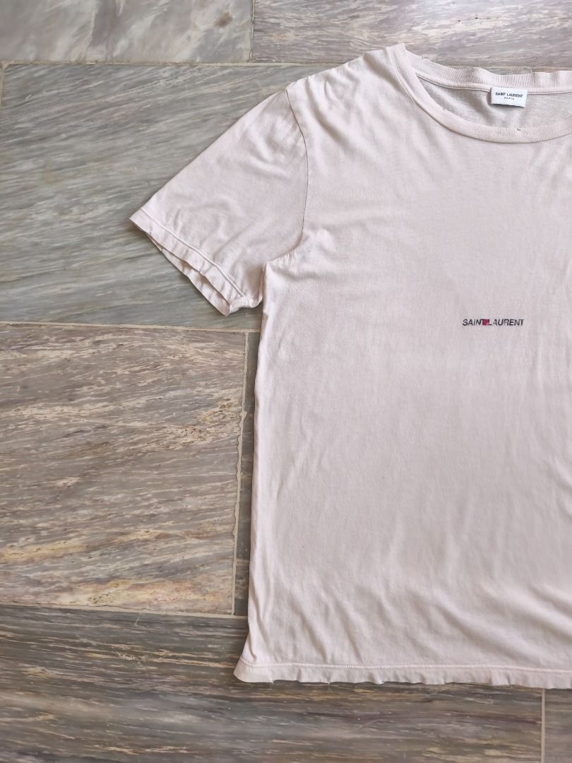 Saint Laurent Paris Tee (Category: Luxury Apparel) located in Lucena. Submitted by 0174.archive (Listing ID 1446167462, Image 2). Description: distressed effect on neck, sleeve & hem very good used condition 9/10 condition rating flaw - crack on print color: off white / cream Actual Measurements (inches) Chest (pit to pit): 21 Length: 27 Shoulder:19 Sleeve: 9 Message before buying if you have question Items are new / pre-loved / second hand used 