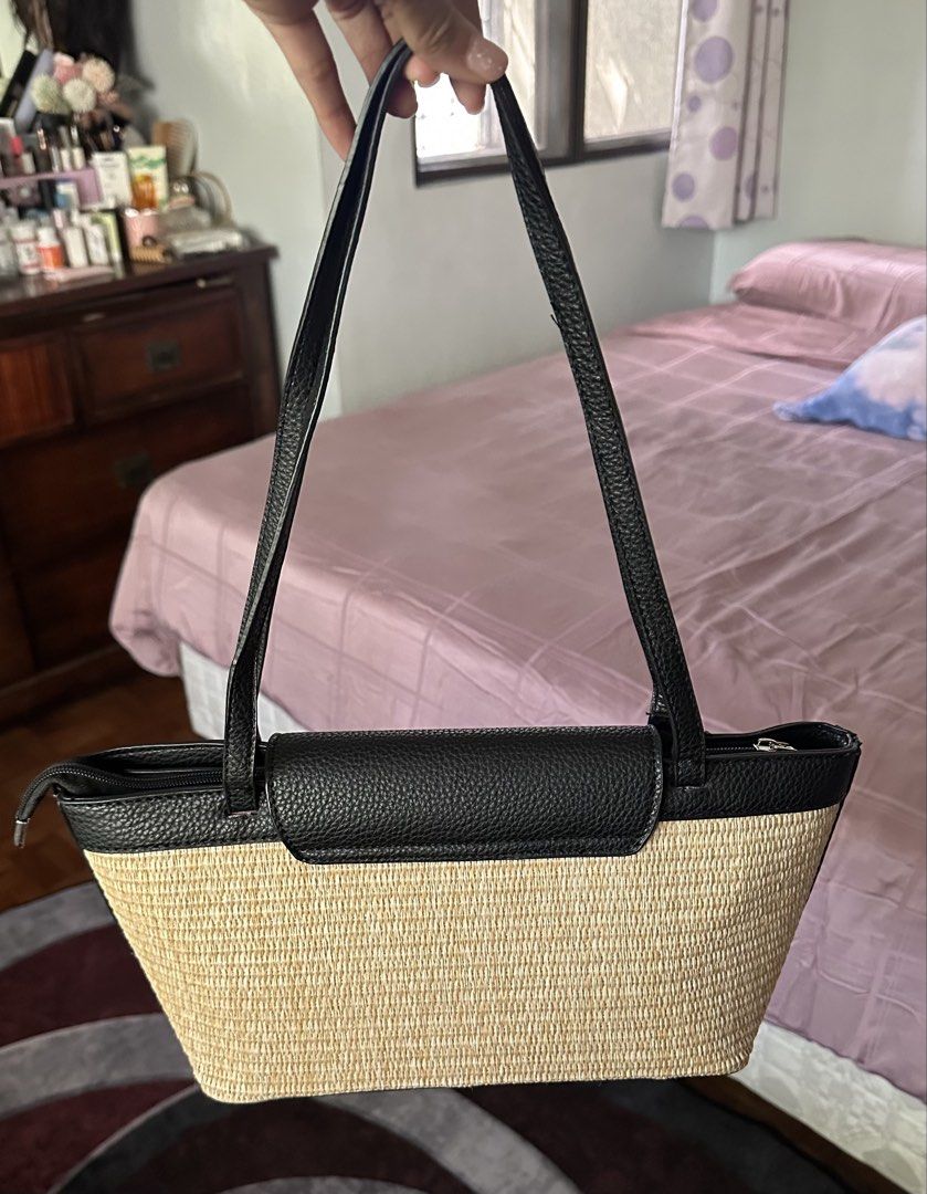 This Prada raffia and black leather tote bag (Category: Luxury Bags & Wallets) located in Makati City. Submitted by janeabat (Listing ID 1446220620, Image 3). Description: - Original GWP Prada - Woven straw body with black leather trim and handles - Iconic Prada triangle logo on front flap - Secure zipper closure at the top - Ideal for everyday use or beach days.