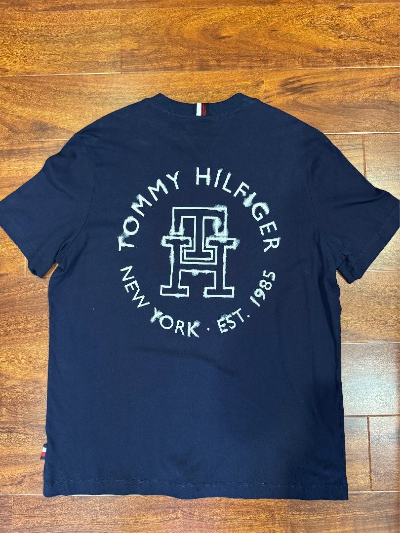 Tommy Hilfiger Navy Blue T-Shirt with Logo (Category: Tshirts & Polo Shirts) located in Kuala Lumpur. Submitted by 4rty9ne (Listing ID 1446177110, Image 1). Description: - Navy blue Tommy Hilfiger t-shirt - Size M. Pit 22 L 28 - Features classic circular logo with 'Tommy Hilfiger New York Est. 1985' text - Short sleeves - Made from comfortable cotton material - Ideal for casual everyday wear.