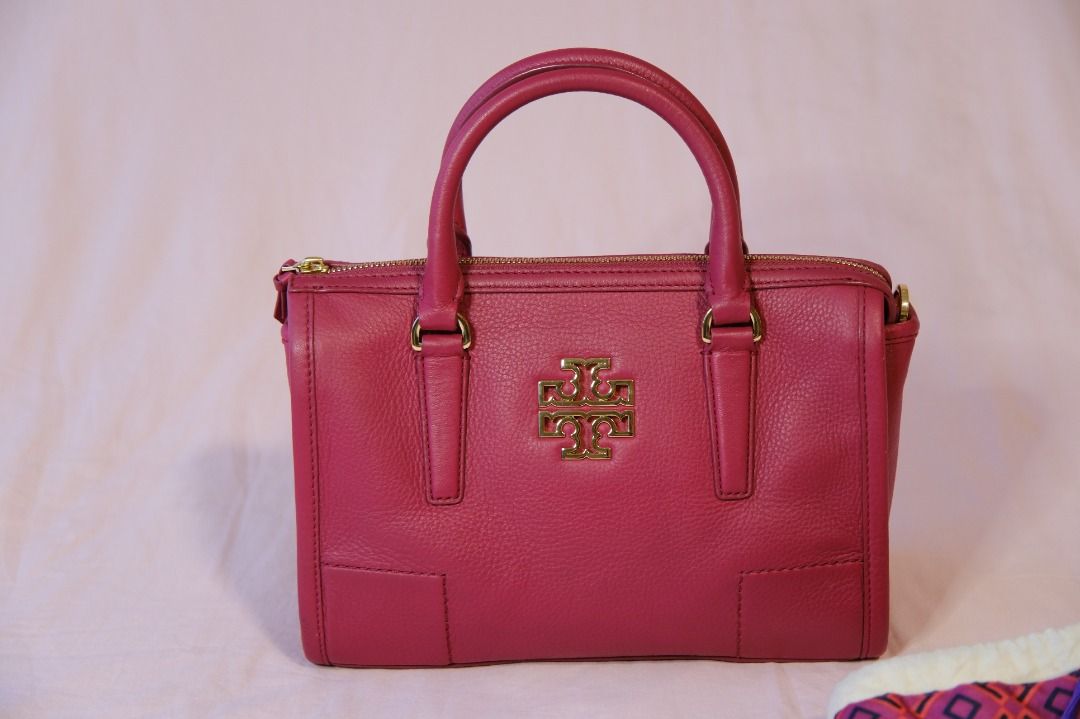 Tory Burch Britten Satchel (Category: Luxury Bags & Wallets) located in Cabuyao City. Submitted by velvetbelleph (Listing ID 1446259738, Image 2). Description: Beautiful Tory Burch Britten Satchel in a vibrant pink color, featuring the signature Tory Burch logo and elegant gold-tone hardware. It comes with structured top handles and a removable long strap, allowing it to be carried as a handbag, shoulder bag, or crossbody bag. Brand: Tory Burch M