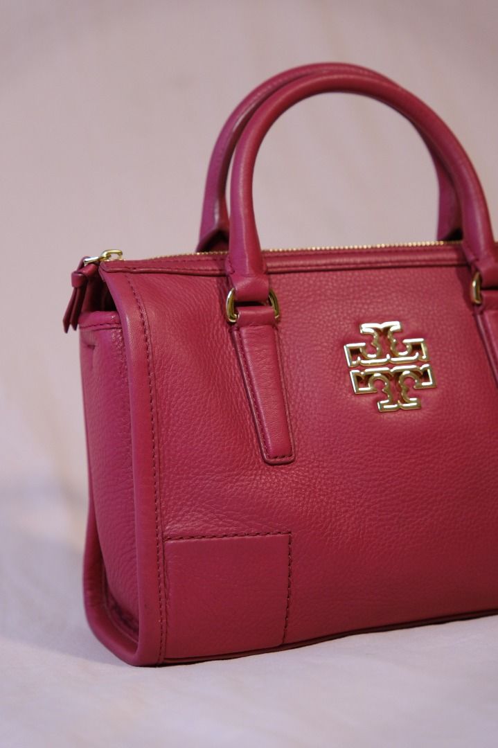 Tory Burch Britten Satchel (Category: Luxury Bags & Wallets) located in Cabuyao City. Submitted by velvetbelleph (Listing ID 1446259738, Image 3). Description: Beautiful Tory Burch Britten Satchel in a vibrant pink color, featuring the signature Tory Burch logo and elegant gold-tone hardware. It comes with structured top handles and a removable long strap, allowing it to be carried as a handbag, shoulder bag, or crossbody bag. Brand: Tory Burch M