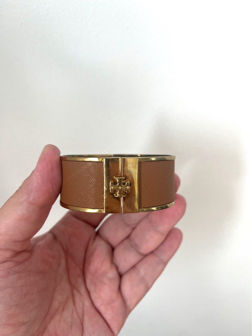Tory Burch Gold and Tan Leather Logo Bangle (Category: Bracelets) located in Manila. Submitted by r.ruth (Listing ID 1446181578, Image 1). Description: - Authentic Tory Burch bangle - Gold-tone finish - Tan leather detailing - Features iconic Tory Burch logo - Secure hinged closure - Shows signs of wear on the inside metal, consistent with normal use - NOT FOR FUSSY BUYER .