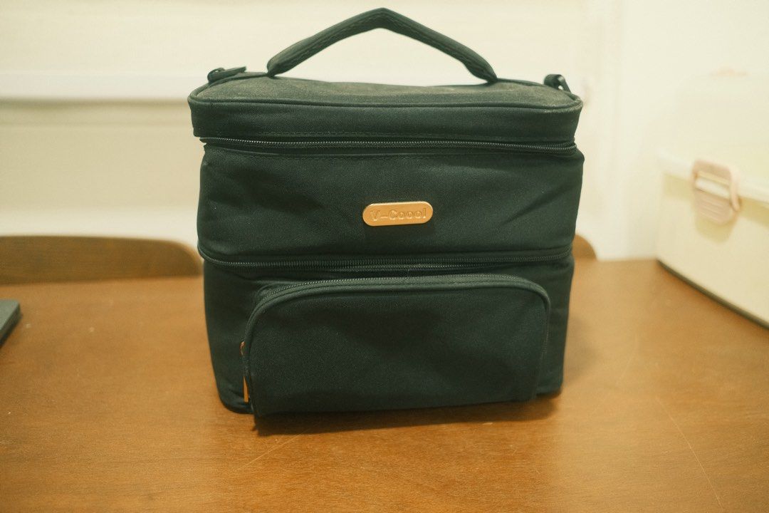V-Cool Black Insulated Cooler Bag (Category: Breastfeeding & Bottle Feeding) located in San Fernando. Submitted by attg_ (Listing ID 1446186805, Image 1). Description: - Black V-Cool cooler bag - Features a top handle for easy carrying - Front zippered pocket for extra storage - Interior mesh pocket section - Note: Some marks inside the main compartment - Zippers are in good working condition.