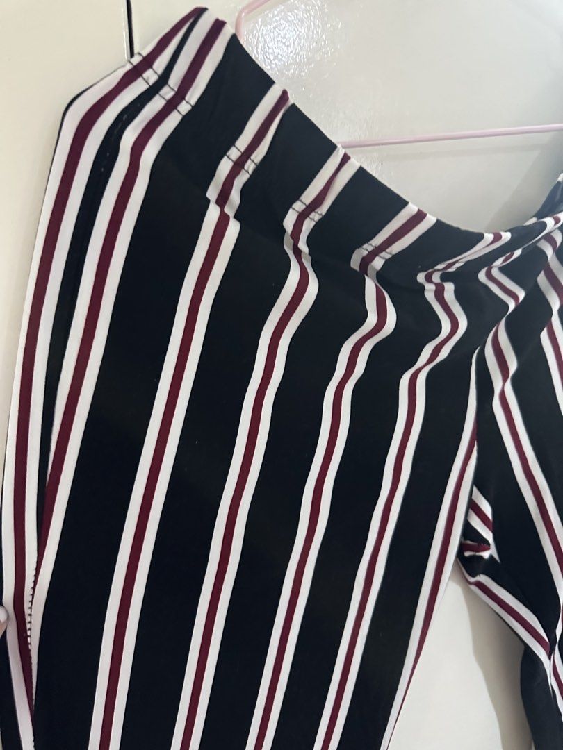 Vibe Sportswear Striped Pants (Category: Other Bottoms) located in Pasig City. Submitted by kyle.closet (Listing ID 1446243528, Image 2). Description: - Stylish black pants with white and maroon stripes. - Flattering high-waisted design with a comfortable elastic waistband. - Trendy wide-leg silhouette with a chic slit at the hem. - Versatile for casual outings or dressing up. - Effortlessly pairs with various tops for a complete look..