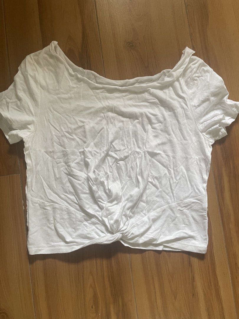 White Cropped Twist Front T-shirt (Category: Shirts) located in Quezon City. Submitted by declutter._.closet (Listing ID 1446193859, Image 1). Description: - White t-shirt with a unique twist knot detail at the front hem. - Short sleeves and a relaxed, comfy fit. - Wider neckline, designed to be worn off-shoulder. - Super casual and versatile, ideal for pairing with high-waisted bottoms..