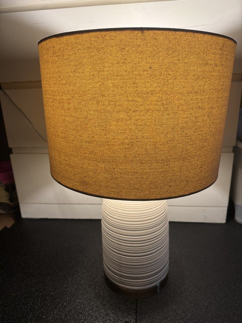 White Textured Ceramic Table Lamp with Beige Drum Shade (Category: Lighting) located in Quezon City. Submitted by slyn1234 (Listing ID 1446168977, Image 3). Description: - White ceramic table lamp - Textured, ribbed base - Subtle gold accent at the bottom - Neutral beige drum lampshade included - Provides a warm, inviting glow - Ideal for bedside tables or living room decor.