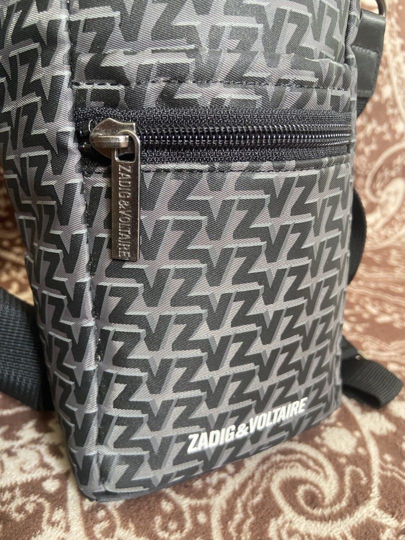 Zadig & Voltaire Monogram Crossbody Bag (Category: Luxury Bags & Wallets) located in Pili. Submitted by rgthriftflip29 (Listing ID 1446181956, Image 2). Description: - Zadig & Voltaire crossbody bag - All-over 'Z' monogram print - Zippered front pocket - Main compartment with snap closure - Adjustable strap - Ideal for on-the-go essentials - Durable material with reinforced base L:5” W:4” D:9” ☑️OVERALL EXCELLENT CONDI ❌ISSUE: MINIMAL SCRATCH ON 