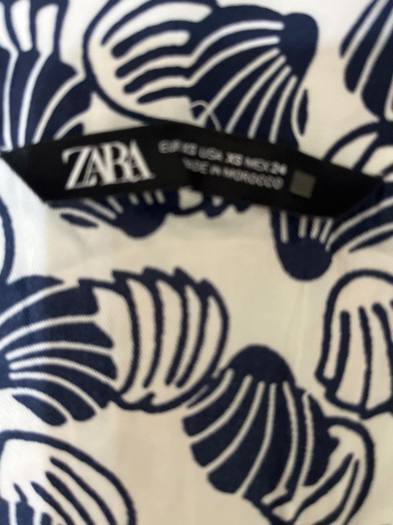 Zara Shell Print Pants XS (Category: Other Bottoms) located in Pasig City. Submitted by ___she___ (Listing ID 1446181039, Image 2). Description: - Stylish white pants featuring a navy blue shell print. - Flattering high-waisted design. - Two decorative button details at the front. - Made from comfortable, lightweight fabric. - Perfect for casual outings or beach vacations..