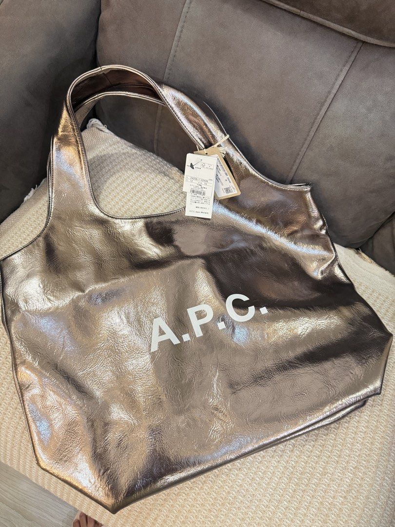 A.P.C. Metallic Tote Bag (Category: Tote Bags) located in Angeles City. Submitted by bagpriceinfiniteluck (Listing ID 1446523830, Image 3). Description: - Shiny metallic tote bag from A.P.C. - Large main compartment for ample storage - Comfortable shoulder straps for easy carrying - Ideal for everyday use or travel - Brand new with original tags attached - A stylish and practical accessory.