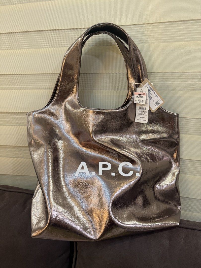A.P.C. Metallic Tote Bag (Category: Tote Bags) located in Angeles City. Submitted by bagpriceinfiniteluck (Listing ID 1446523830, Image 1). Description: - Shiny metallic tote bag from A.P.C. - Large main compartment for ample storage - Comfortable shoulder straps for easy carrying - Ideal for everyday use or travel - Brand new with original tags attached - A stylish and practical accessory.