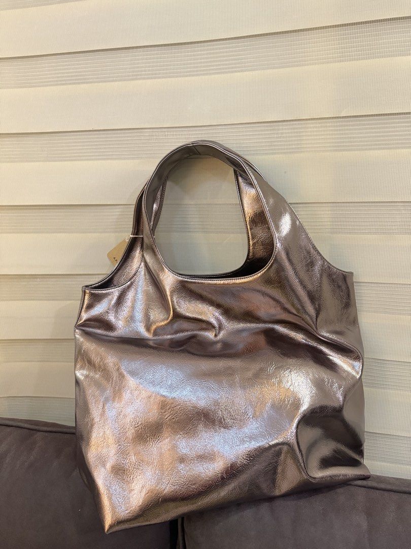 A.P.C. Metallic Tote Bag (Category: Tote Bags) located in Angeles City. Submitted by bagpriceinfiniteluck (Listing ID 1446523830, Image 2). Description: - Shiny metallic tote bag from A.P.C. - Large main compartment for ample storage - Comfortable shoulder straps for easy carrying - Ideal for everyday use or travel - Brand new with original tags attached - A stylish and practical accessory.