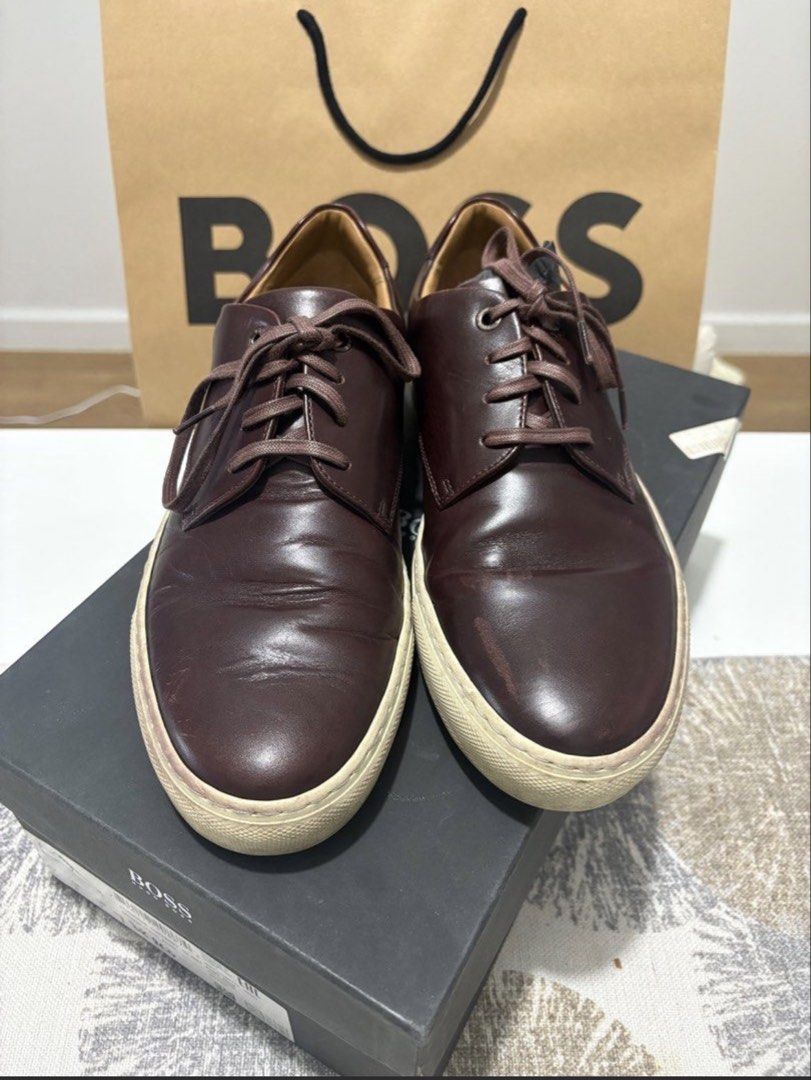 BOSS Brown Leather Lace-Up Sneakers (Category: Sneakers) located in Valenzuela. Submitted by kat_preloveditems (Listing ID 1446496639, Image 1). Description: - Original BOSS Brown Leather Sneakers -Made in Italy - Classic lace-up style - Durable rubber sole - Ideal for casual wear - Comes with original box and paper bag - Minor scuffs on soles and leather (expected with use) MOP: Gcash QC Vertis area SF c/o buyer via lalamove or J&T.