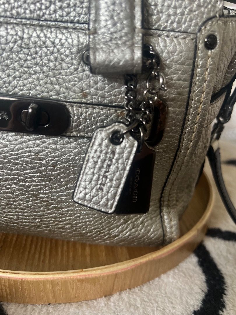 Coach Pebble Leather Metallic Silver Handbag (Category: Luxury Bags & Wallets) located in Lubao. Submitted by inna_segovia20 (Listing ID 1446411740, Image 2). Description: - Metallic silver Coach handbag - Limited Edition - Pebbled leather texture - Top zip closure - Front pocket with turn-lock detail - Interior zip pocket - Detachable crossbody strap included - Minor exterior marks visible (please check photos).