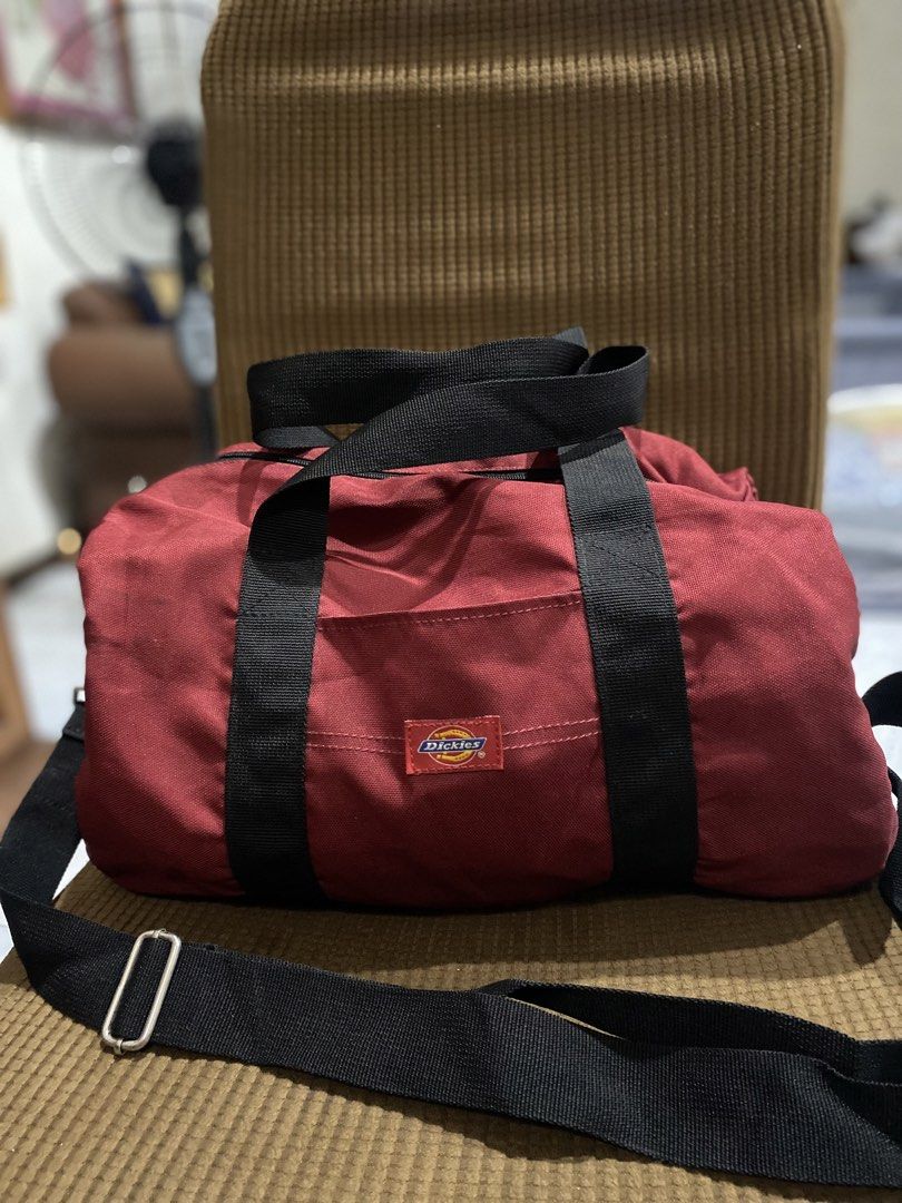 Dickies Red Duffle Bag with Shoulder Strap (Category: Sling Bags) located in Cadiz. Submitted by saveandstyleph (Listing ID 1446385102, Image 1). Description: - Red Dickies duffle bag - Features top handles and a detachable shoulder strap - Main compartment with zip closure - Includes a small front pocket - Perfect for gym sessions or weekend getaways - Made from durable material - Minor signs of use visible inside.