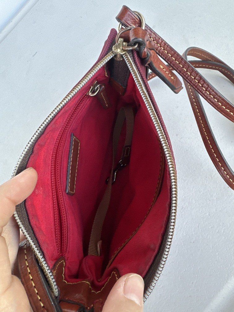 Dooney & Bourke Nylon Crossbody Pouchette (Category: Cross-body Bags) located in Manila. Submitted by classywardrobemanila (Listing ID 1446432571, Image 3). Description: Like new, just needs cleaning but all intact. Dooney & Bourke Nylon Crossbody Pouchette features a maroon nylon body and a stitched leather duck logo patch. Brand: Dooney & Bourke Material: Lightweight nylon with leather trim Features: Adjustable shoulder strap and a zip-top clos