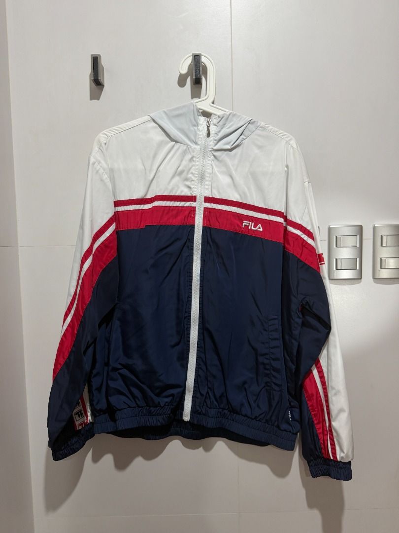 FILA Windbreaker Jacket Hooded White Navy Red (Category: Coats, Jackets and Outerwear) located in Mandaluyong City. Submitted by kayechx (Listing ID 1446496985, Image 1). Description: - Classic FILA windbreaker jacket - Color: White with navy and red stripes - Features a hood - Zipper closure - Elasticated cuffs and hem - FILA logo prominently displayed on chest, sleeves, and back - Ideal for casual wear or sports activities - price SLIGHTLY nego