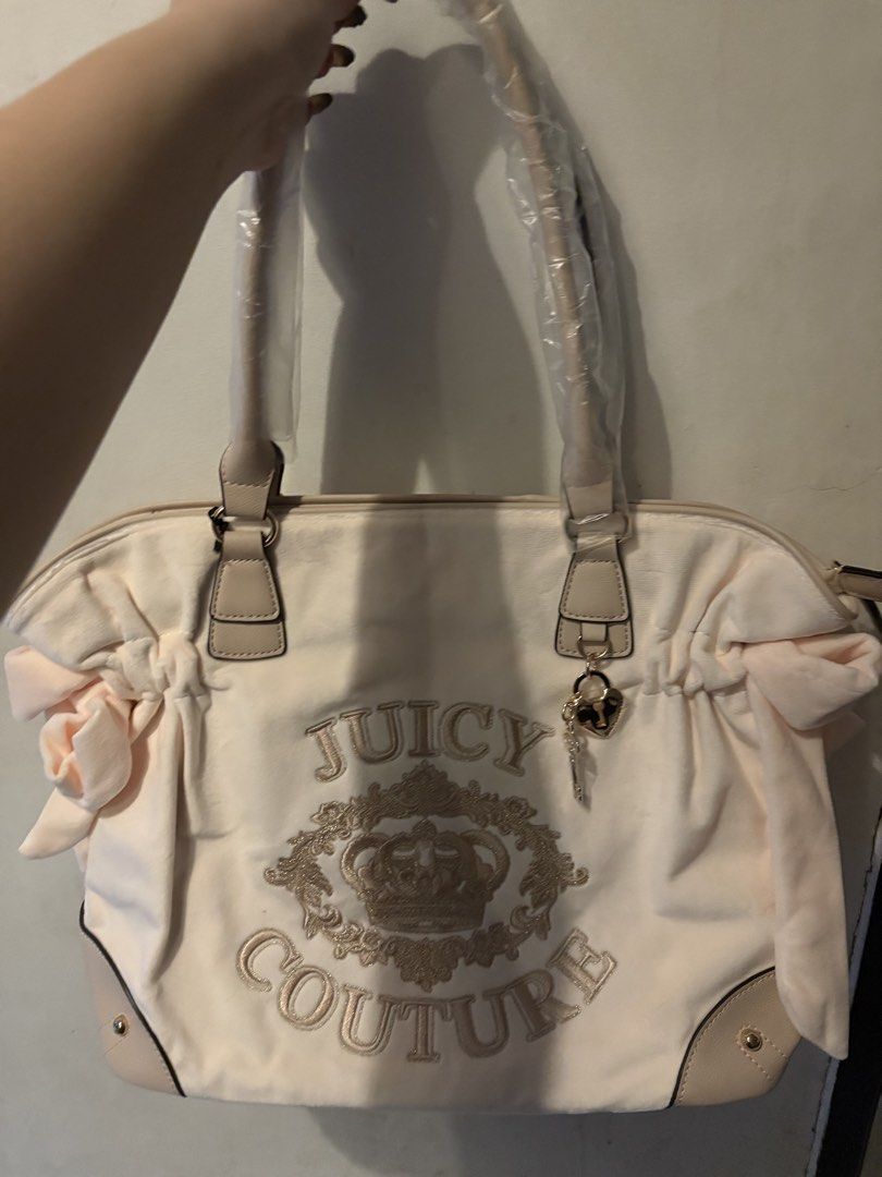 Juicy Couture Velour Tote Bag (Category: Tote Bags) located in Imus. Submitted by imaubleee16 (Listing ID 1446469919, Image 1). Description: - Juicy Couture cream velour tote bag - Signature crown logo embroidery - Cute bow details on the sides - Comes with a heart charm and key detail - Handles still have original plastic wrap on them.