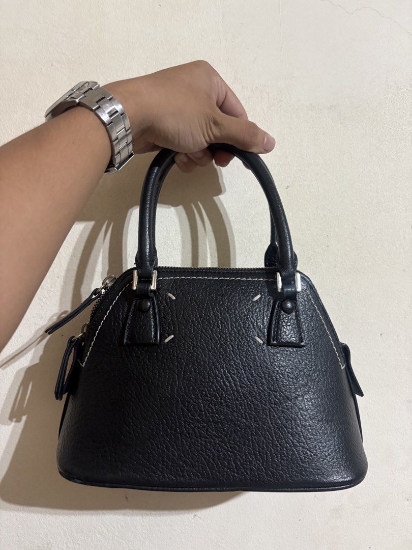 Maison Margiela 5AC Micro bag Leather (Category: Cross-body Bags) located in Dinalupihan. Submitted by hell.thrift (Listing ID 1446408150, Image 2). Description: This black pebbled calf leather Maison Margiela 5AC Micro bag features the brand’s iconic numerical logo patch and a detachable silver-tone chain strap. -Can be sling bag or hang bag Issue sing of usage not noticeable at the bottom part minimal only 9/10 Condition .