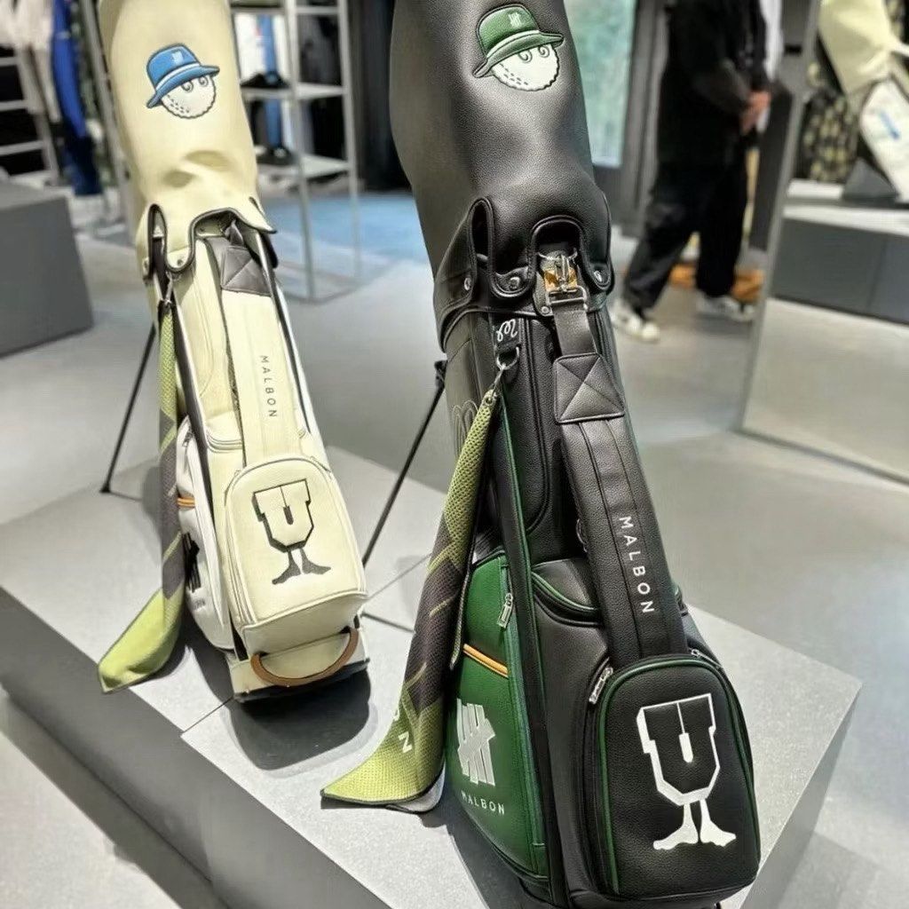 Malbon x Undefeated Golf Stand Bag (Category: Golf) located in Manila. Submitted by sunyellow611674 (Listing ID 1446425570, Image 2). Description: - Malbon x Undefeated collaboration golf stand bag - Available in Cream or Black colorways - Features iconic Malbon golf ball logo and Undefeated branding - Built-in stand for convenient access on the course - Perfect for carrying your golf clubs in style and with functionality.