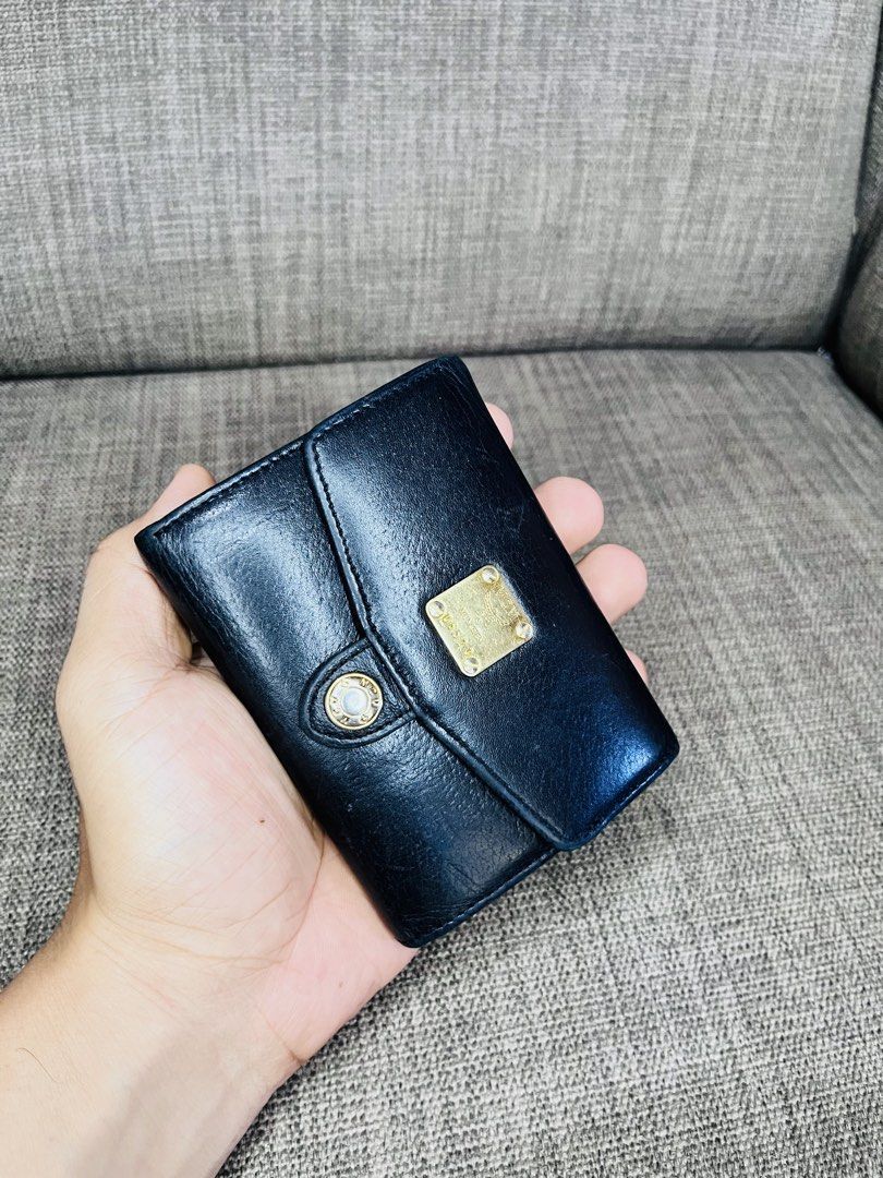 MCM Black Leather Tri-Fold Wallet (Category: Luxury Bags & Wallets) located in Ballesteros. Submitted by sat_b3 (Listing ID 1446355247, Image 2). Description: - MCM tri-fold wallet - Black leather exterior with tan interior - Card slots and coin pouch included - Elegant gold hardware details - Shows some signs of wear on the exterior - Interior is clean and well-maintained- sa plastic lang na lagayan ng pic- nahawaan ng kulay.. - very good pa nam