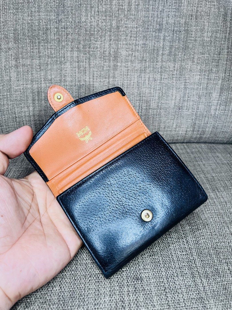 MCM Black Leather Tri-Fold Wallet (Category: Luxury Bags & Wallets) located in Ballesteros. Submitted by sat_b3 (Listing ID 1446355247, Image 1). Description: - MCM tri-fold wallet - Black leather exterior with tan interior - Card slots and coin pouch included - Elegant gold hardware details - Shows some signs of wear on the exterior - Interior is clean and well-maintained- sa plastic lang na lagayan ng pic- nahawaan ng kulay.. - very good pa nam