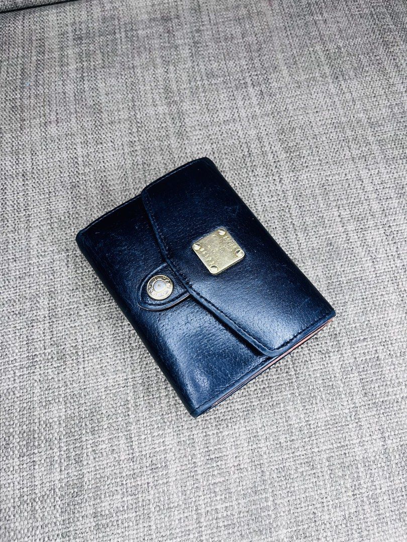 MCM Black Leather Tri-Fold Wallet (Category: Luxury Bags & Wallets) located in Ballesteros. Submitted by sat_b3 (Listing ID 1446355247, Image 3). Description: - MCM tri-fold wallet - Black leather exterior with tan interior - Card slots and coin pouch included - Elegant gold hardware details - Shows some signs of wear on the exterior - Interior is clean and well-maintained- sa plastic lang na lagayan ng pic- nahawaan ng kulay.. - very good pa nam