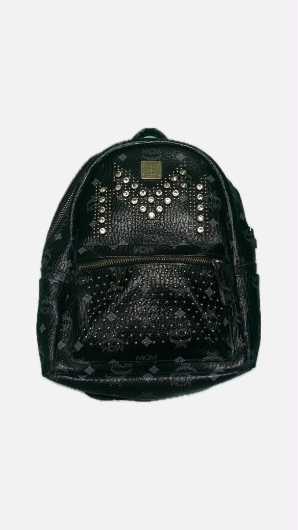 MCM Studded Monogram Backpack Black (Category: Luxury Bags & Wallets) located in Makati City. Submitted by preloved_plc (Listing ID 1446359856, Image 1). Description: - Authentic black MCM backpack - Signature monogram print - Decorative silver-tone studs on front - Main compartment with interior pocket - Adjustable shoulder straps - Minor signs of wear on hardware and straps.