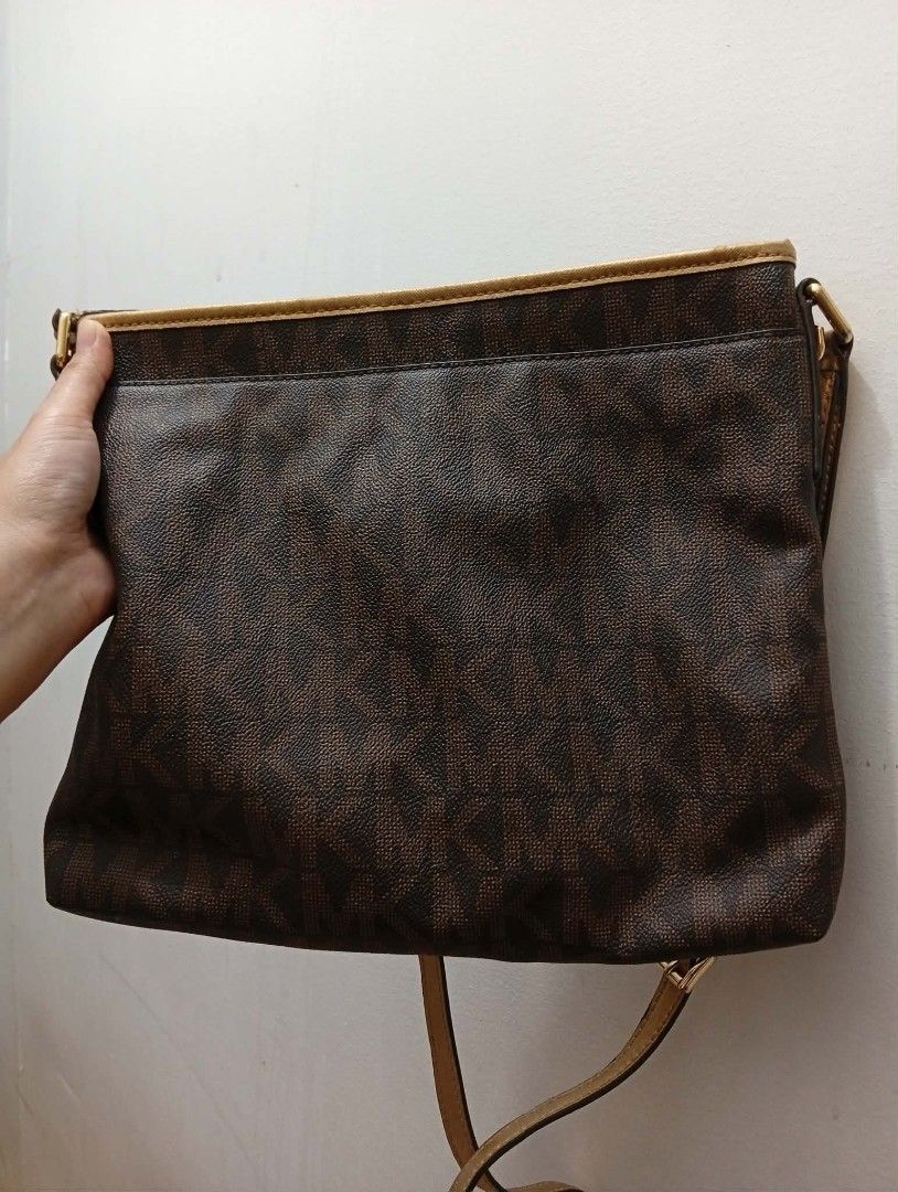 Michael Kors Monogram Shoulder Bag Gold Accents (Category: Luxury Bags & Wallets) located in Quezon City. Submitted by kinopipanda (Listing ID 1446530886, Image 2). Description: - Authentic Michael Kors shoulder bag in classic brown. - Features the iconic MK monogram print all over. - Elegant gold accent panel on the front for a touch of luxury. - Adjustable strap for comfortable, customized wear. - Generously sized interior, ideal for carrying y