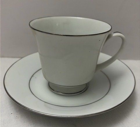 Noritake Legacy "Regency Silver" Cup and Saucer Set (Category: Coffee & Tea Tableware) located in Quezon City. Submitted by lopezlavi (Listing ID 1446417348, Image 1). Description: The Design relies entirely on a crisp, stark white porcelain canvas featuring no central patterns, floral decorations, or graphics. The clean look is defined by a thin, highly polished platinum silver rim running along the top of the flared cup and outer edge of the sa