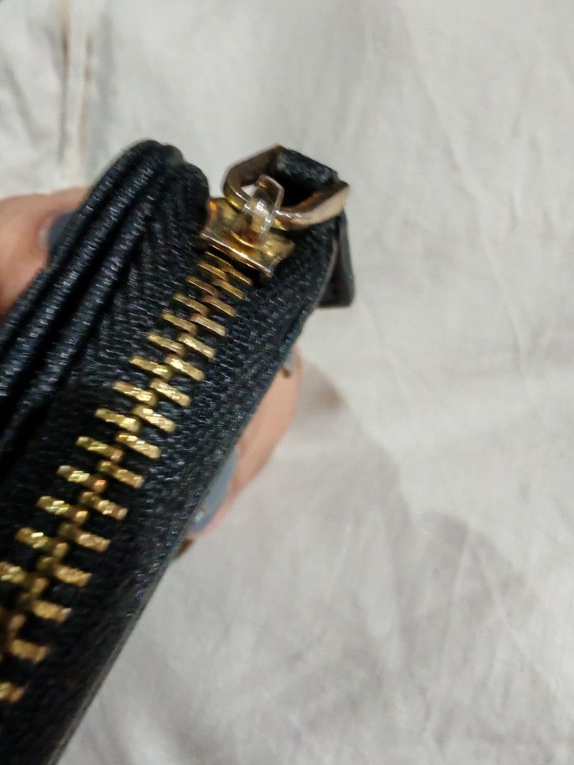 Prada Black Saffiano Wallet (Category: Luxury Bags & Wallets) located in Davao. Submitted by athenaprelovedph (Listing ID 1446461036, Image 3). Description: - Prada bifold wallet - Material: Black saffiano leather - Closure: Gold zipper - Interior: Two compartments - Size: Small and compact, fits easily in any bag - Functionality: Great for organizing coins and cards - Condition: Shows some signs of wear on the zipper and corners.
